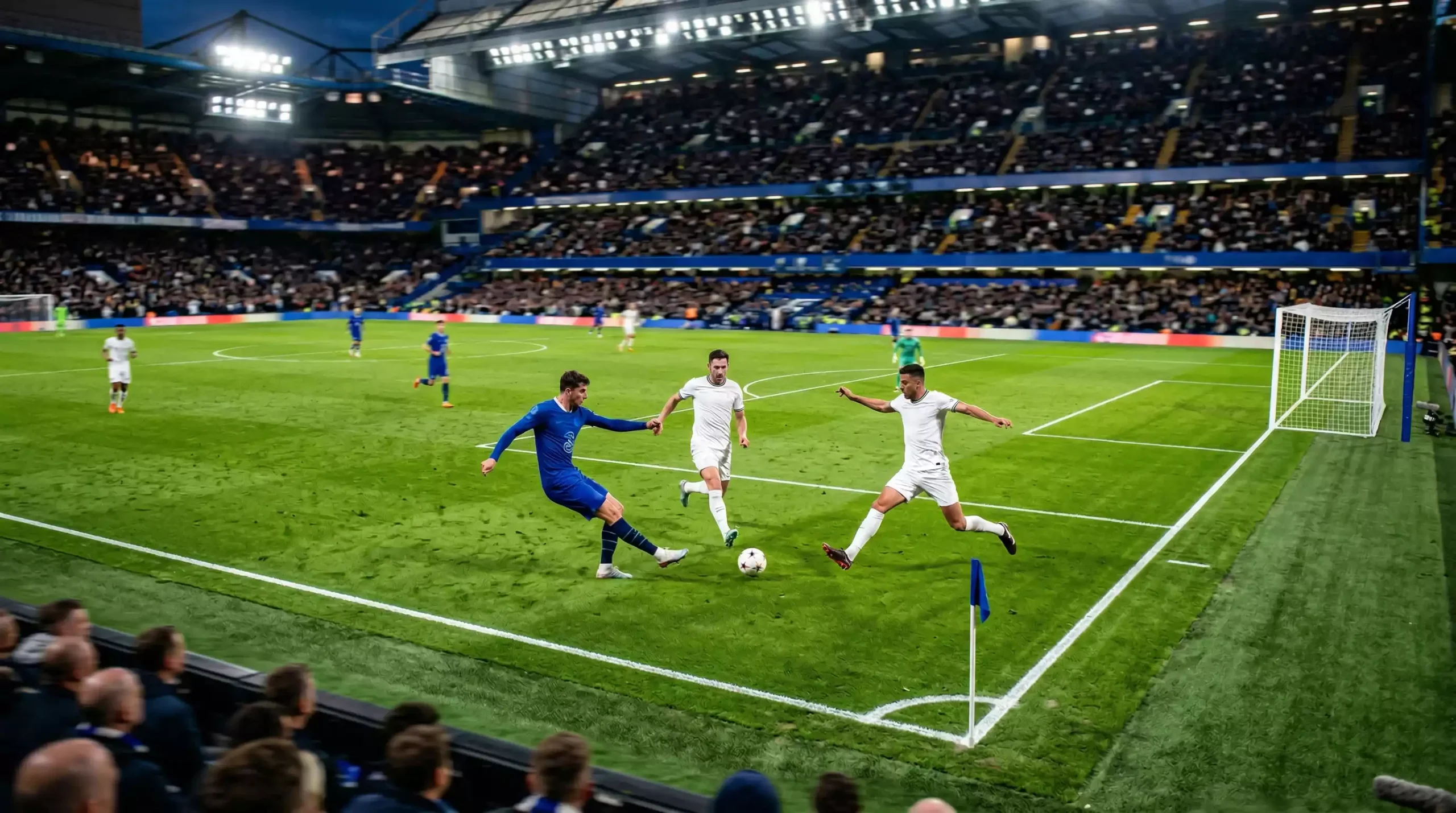 Partido de fútbol en curso visto desde la tribuna con jugadores en acción sobre césped